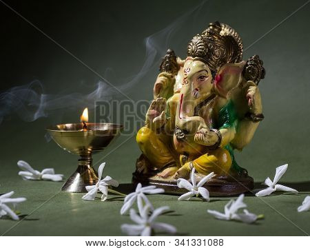 Hindu God Ganesha. Ganesha Idol. A Colorful Statue Of Ganesha Idol On Dark Background. Space For Tex
