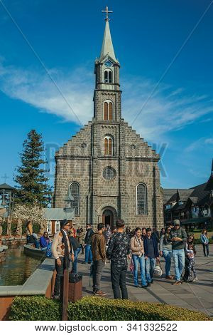 Gramado, Brazil - July 21, 2019. Church Facade With Steeple And People On A Little Square With Sunny