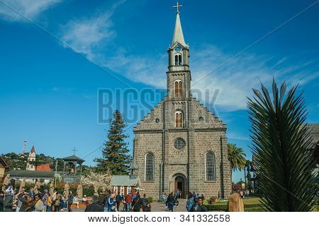 Gramado, Brazil - July 21, 2019. Church Facade With Steeple And People On A Little Square With Sunny