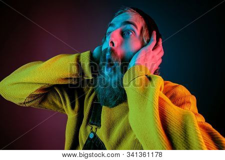 Exremely Shocked, Astonished. Caucasian Mans Portrait On Gradient Studio Background In Neon Light. B