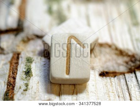 Wooden Rune Laguz Close-up On A Wooden Background. Soft Focus