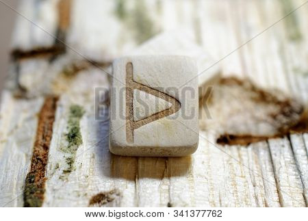 Wooden Rune Thurisa Close-up On A Wooden Background. Soft Focus