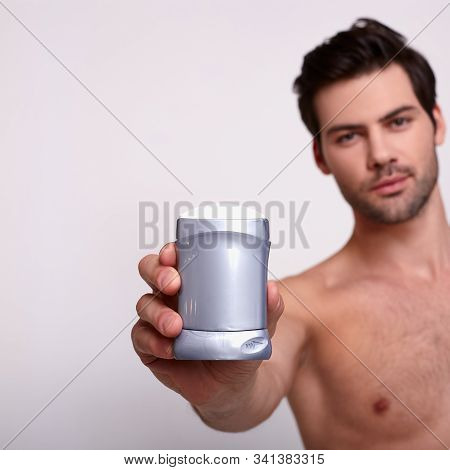 Bare Nice Sexy Guy Stand On White Background, Holds In His Right Hand Deodorant And Looks At Frame S