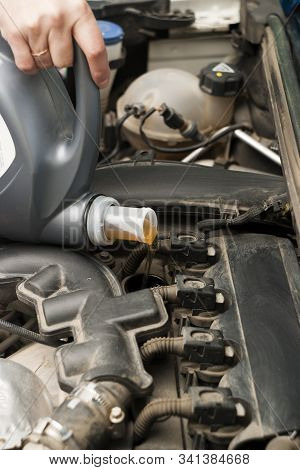 Refueling With Car Engine Oil. The Engine Compartment, Canister And Engine Oil Are Poured Into The O
