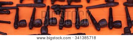 Different Pipes Smoking Tobacco On An Orange Background. Banner.