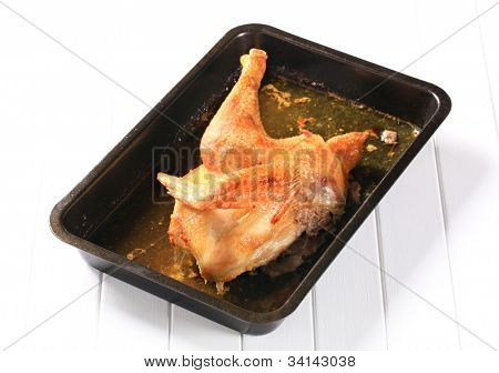 Halve kip op het bot gebakken op een zwart rechthoekig frier