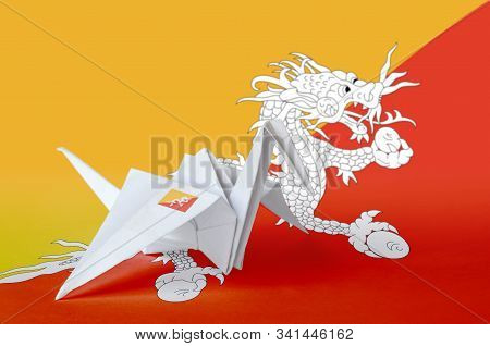 Bhutan Flag Depicted On Paper Origami Crane Wing. Handmade Arts Concept