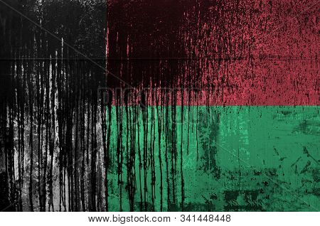 Madagascar Flag Depicted In Paint Colors On Old And Dirty Oil Barrel Wall Closeup. Textured Banner O