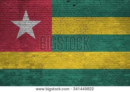 Togo Flag Depicted In Paint Colors On Old Brick Wall. Textured Banner On Big Brick Wall Masonry Back