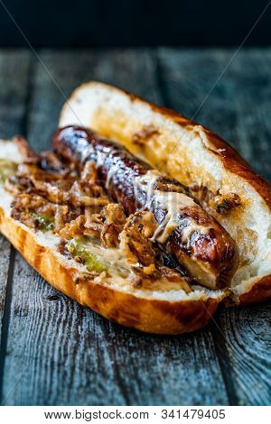 Hot Dog With Caramelized Onion, Cheddar And Gruyere Cheese Sauce On Wooden Surface With Potatoes.