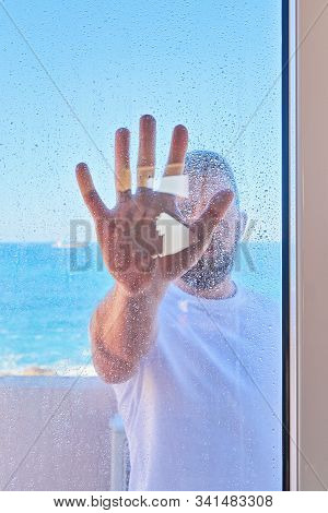 Caucasian Man With Raised Hand Through Window Glass. Problem Of Social Domestic Violence Concept