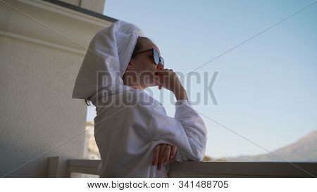 A Girl In A White Robe Stands On The Balcony And Enjoys. Sexy Girl In White Robe Stands On The Balco