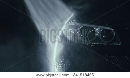 Car Headlight Wash. Washing Modern Vehicle Body By High Pressure Jet Wash Hose Water. Auto Glass Hea
