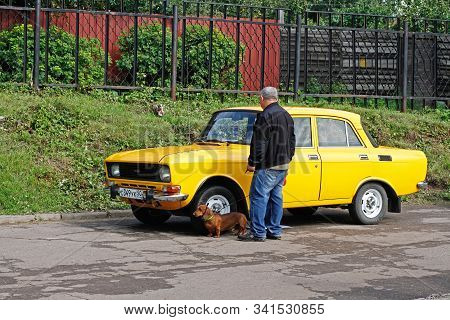 Pushkino, Moscow Region, Russia - July 13, 2019: An Elderly Man With A Dachshund Examines Soviet Veh