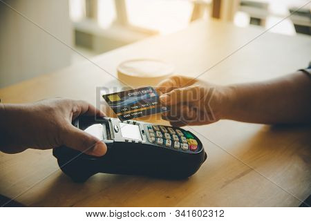 Close Up Of Hand Using Credit Card To Pay By Sending The Credit Card To The Staff At The Credit Card