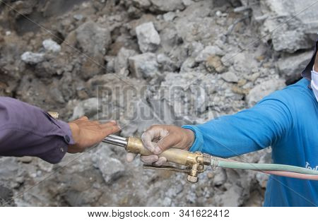 Two Workers Are Helping To Cut The Steel Wire By Gas In The Concrete Pile.