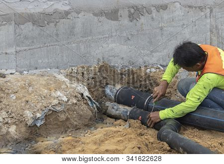 Two Workers Are Helping To Cut The Steel Wire By Gas In The Concrete Pile.
