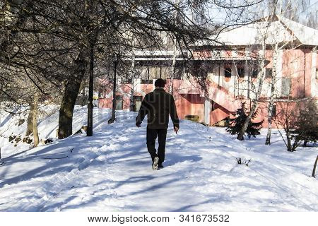 A Silhouette Of Man Move In Snowy Day. Concept Maniac. Winter Day. Park