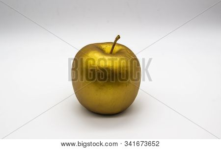 A Golden Apple On A White Background