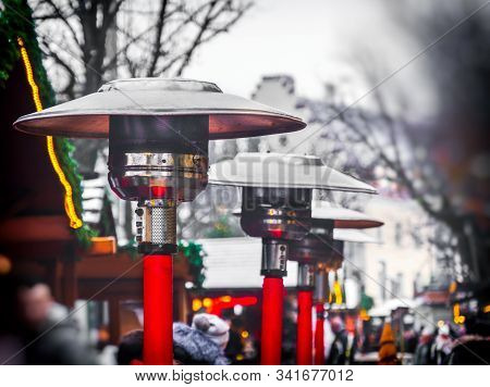 Row Of Gas Patio Heaters With Propane Heat Lamp On The Street In Winter Day .