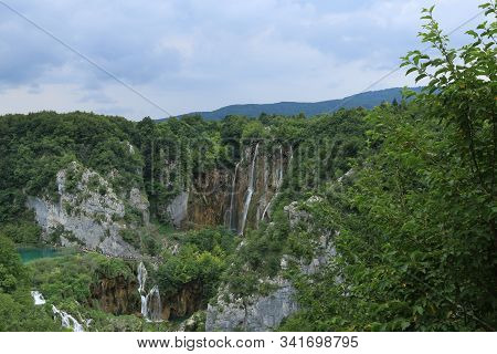 Small Waterfalls In The Wild Green Trees And River