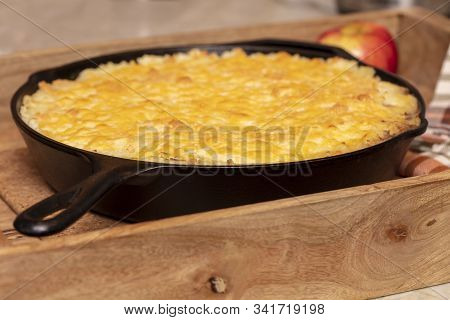 Shephers Pie Baked In A Cast Iron Skillet And Placed On A Wood Tray With An Apple And Napkins