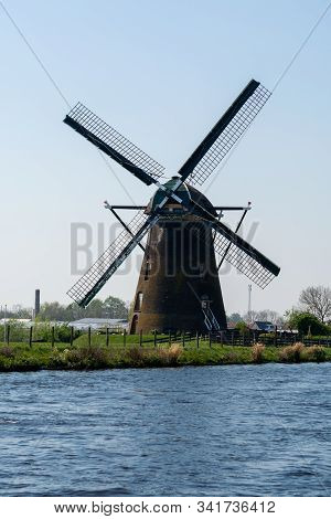 Traditional Dutch Wind Mill Built Along The Canal In North Holland, Spring Landscape