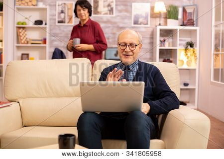 Elderly Old Couple Using Modern Laptop To Chat With Their Grandson