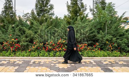 Qom, Iran - May 2019: Iranian Man Walking A Street In Qom, Which Is Considered By Shia Muslims To Be