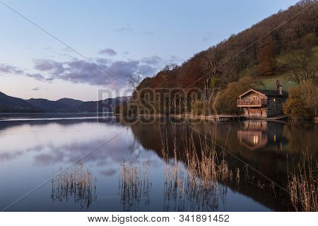Stunning Sunrise Autumn Fall Landscape Image Of Ullswater In Lake District With Golden Sunlight
