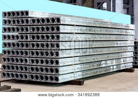 New Hollow Core Slabs Piled On A Pile At The Warehouse Of A Plant For The Production Of Reinforced C