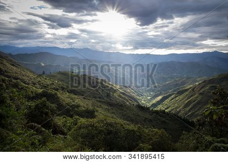 Panoramic View Of The Ecuadorian Sierra At Sunset. There Are Big Clouds, Mountains, Shrubs And Trees