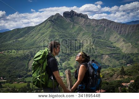 Backpacker Couple Holding Hands Surrounded By A Natural Landscape. Vilcabamba, Ecuador