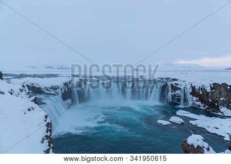 Beautiful Winter Godafoss Waterfall In Iceland, Covered In Snow