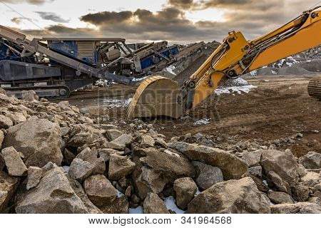 Stone Crusher And Excavator In An Open Pit Mine. Granite Mine To Make Gravel