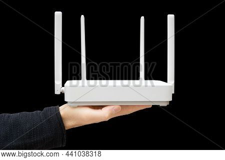 Male Hand Holding A Modern Dual Band Router Against A Black Background. Upgrading To Wi-fi 6.