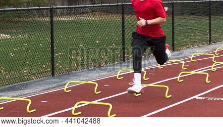 High School Track And Field Runner Running Over Yellow Six Inch Mini Banana Hurdles During The Wicke