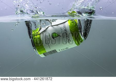 Close Up View Of Can Of Pear Sider Falling Into Water Isolation On Background. Sweden. Uppsala. 11.2
