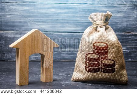 Wooden House And A Money Bag. Home Purchase, Investment In Real Estate Construction. Mortgage Loan. 
