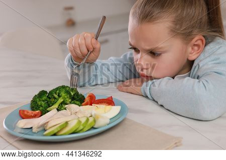 Cute Little Girl Refusing To Eat Dinner In Kitchen
