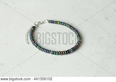 Black Fire Opal Handemade Bracelet Lies On Light Background. Bracelet Made Of Natural Stones Black F