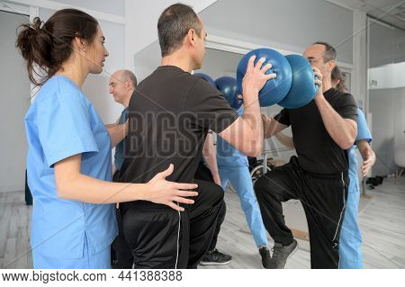 Group Of People With Disability Exercising At Rehabilitation Clinic. High Quality Photo