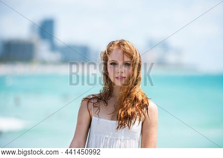 Sunner Portrait Of Redhead Beautiful Girl At Beach. Young Tanned Woman Enjoying Breeze At Seaside. C