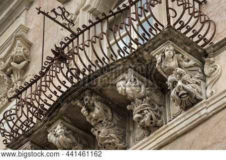 Beautiful baroque mascaron ornament of a balcony in the old town of Ragusa, Sicily, Italy