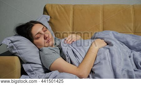 Young Brunette Woman With Red Nose And Eyes Falls Ill And Lies On Comfortable Sofa Under Grey Warm B