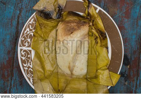 Stuffed Tamale Served On Wooden Table, Stuffed Tamale On Banana Leaf Served On Wooden Table, Typical