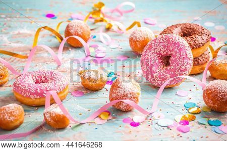 Krapfen, Berliner and donuts with streamers and confetti. Colorful carnival, birthday and Fasching image