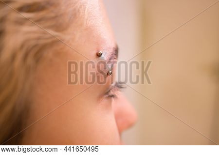 Professional Placing The Jewel Of Piercing On The Temple On The Head With Ball. Tragus Type.