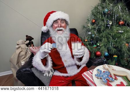 Santa Claus eating cookies and drinking milk left out on Christmas, focus on gloves and face