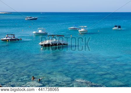 Protaras, Cyprus - August 5 2020: People Swimming In The Sea With Speedboats Floating On Water. Summ